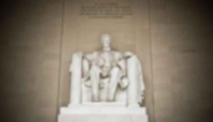 Blurred statue of seated historical figure.
