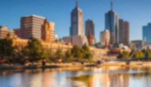 Blurred cityscape with river and skyscrapers.