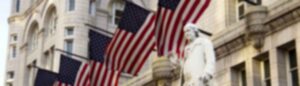 Statue with American flags outside historic building.