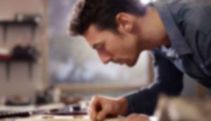 Man focused on woodworking project indoors.