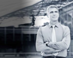 Businessman standing confidently outside modern building.