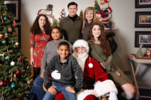 Family posing with Santa Claus at Christmas.