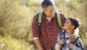 Blurry image of man and child outdoors.