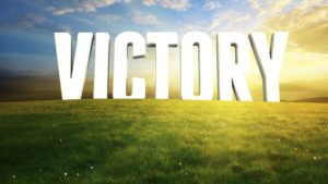 Victory text on grassy field, sunny background.